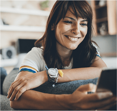 A smiling woman looking at her phone