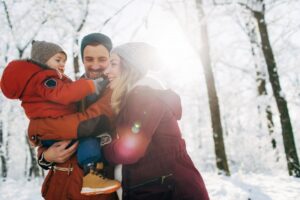 mom-dad-child-outside-in-snowy-landscape