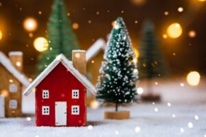 red-wooden-cutout-house-with-small-decorative-tree-and-snow-falling