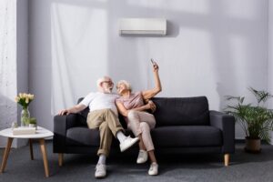 senior-couple-on-sofa-with-mini-split-on-wall