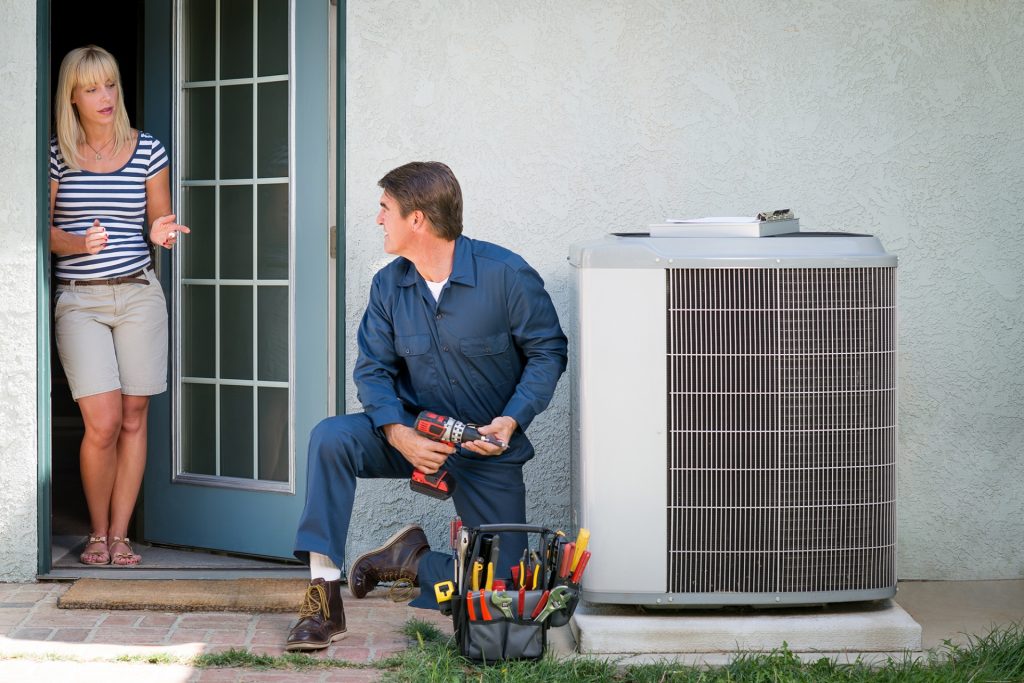 technician-working-on-ac-talking-with-customer